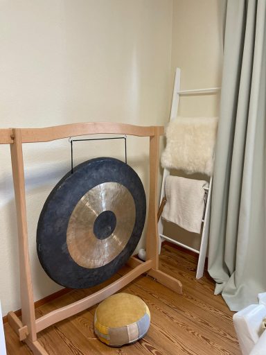 Achtsamkeit und Klangschalen: Behandlungsraum von achtklang in Rastatt; ein großer Gong vor einem Sitzkissen