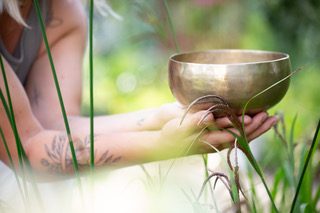Klangschalentherapie und Sound Bath in Rastatt bei Karlsruhe/Baden-Baden: eine tibetische Klangschale, in Händen gehalten, in der Natur