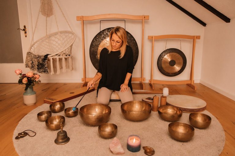 Klangschalentherapie im Raum Rastatt nähe Karlsruhe: Jessica Fettig sitzt vor Klangschalen, Gongs und Musikinstrumenten