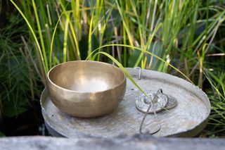 Klangschalentherapie bei achtklang in Rastatt, Raum Karlsruhe/Baden-Baden: eine tibetische Klangschale und eine Zimbel vor Grashalmen